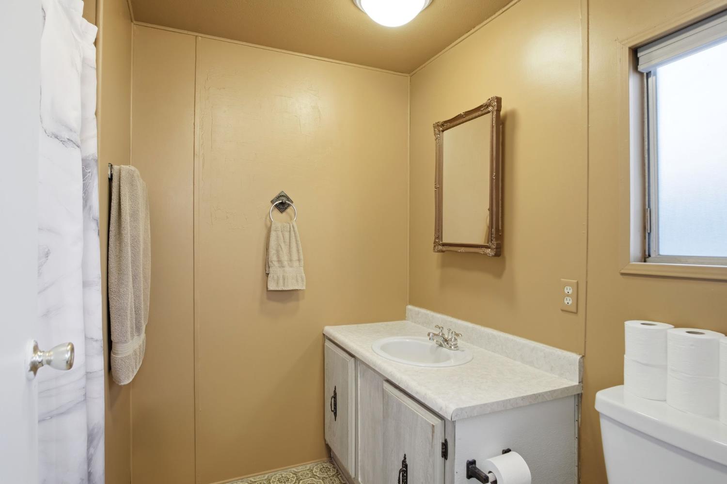 1400 Meredith Avenue, Unit 55 Gustine, CA 95322 - Photo 12 of 19 a bathroom with a sink and mirror