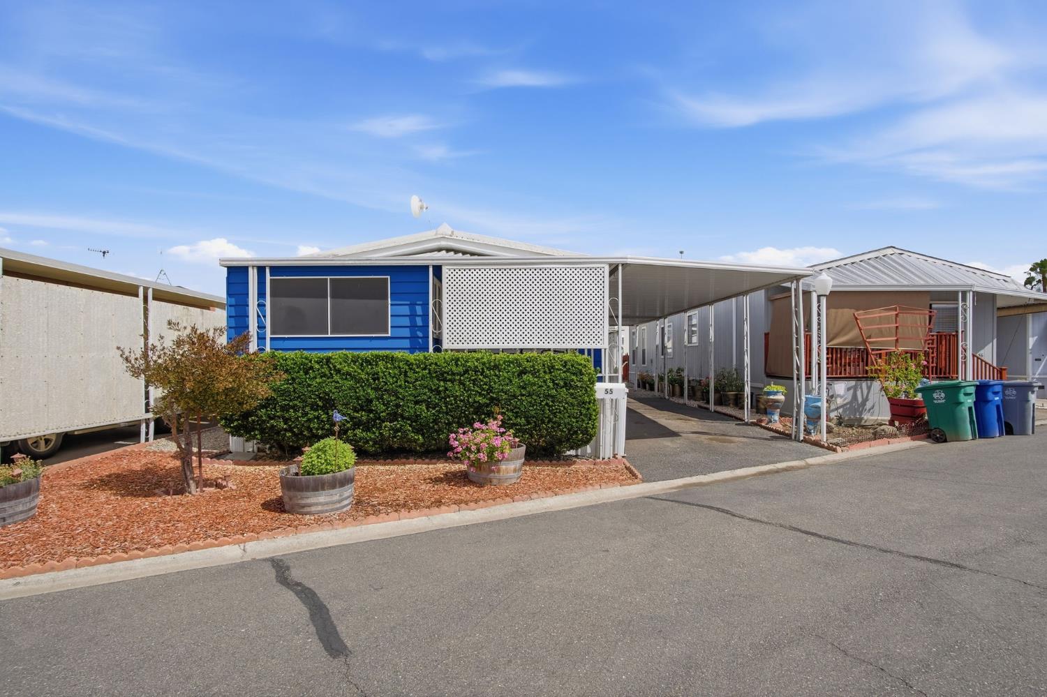 1400 Meredith Avenue, Unit 55 Gustine, CA 95322 - Photo 3 of 19 a view of a house with potted plants and a garage