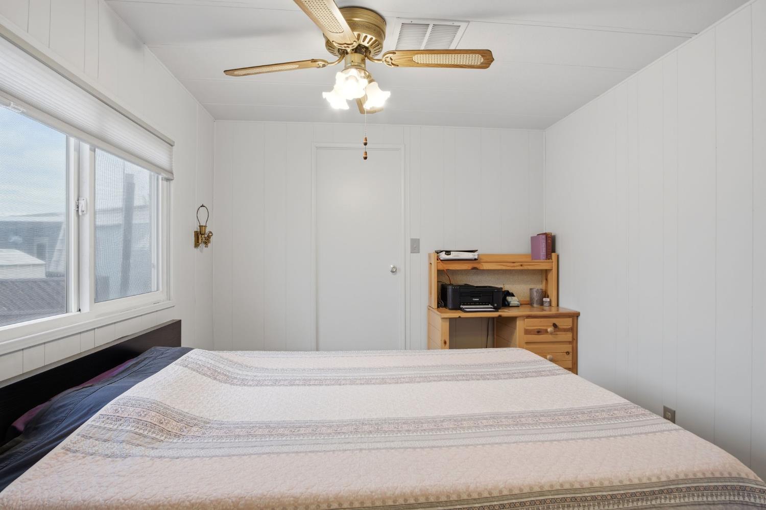 1400 Meredith Avenue, Unit 55 Gustine, CA 95322 - Photo 10 of 19 a bedroom with a bed and a chandelier