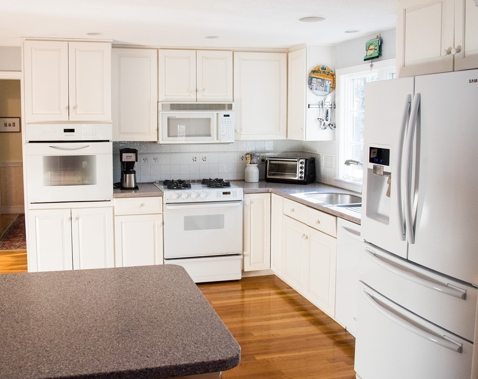 83 Concord Road Acton, MA 01720 - Photo 9 of 30 a kitchen with white cabinets and white appliances