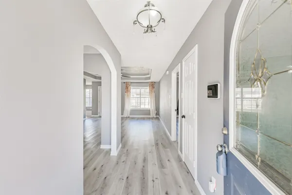 a view of a hallway with wooden floor and staircase