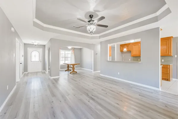 a view of a livingroom with wooden floor and a ceiling fan