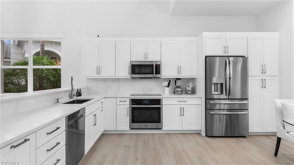 6172 Dogleg Drive Naples, FL 34113 - Photo 26 of 45 a kitchen with stainless steel appliances a stove a sink and a refrigerator