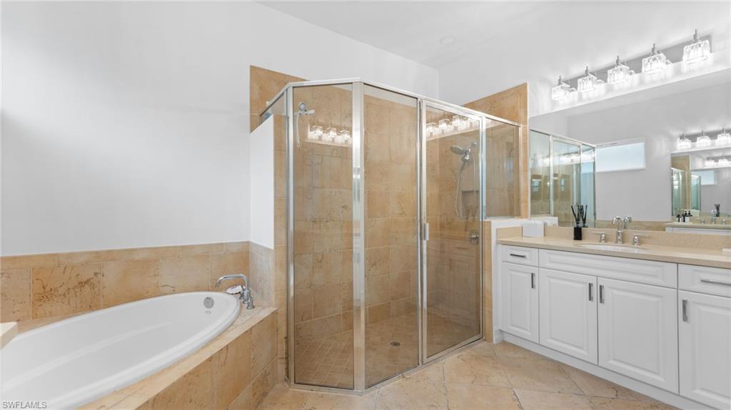 6172 Dogleg Drive Naples, FL 34113 - Photo 31 of 45 a bathroom with a tub a sink and mirrors