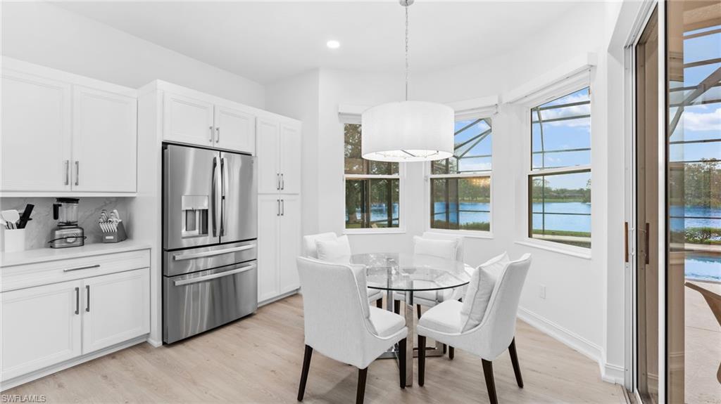 6172 Dogleg Drive Naples, FL 34113 - Photo 35 of 45 a kitchen with stainless steel appliances a dining table chairs refrigerator and cabinets