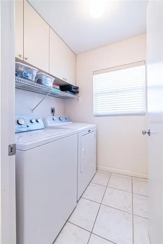 a utility room with cabinets washer and dryer