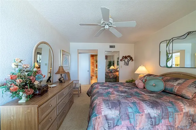 a bedroom with a bed potted plant and a dresser