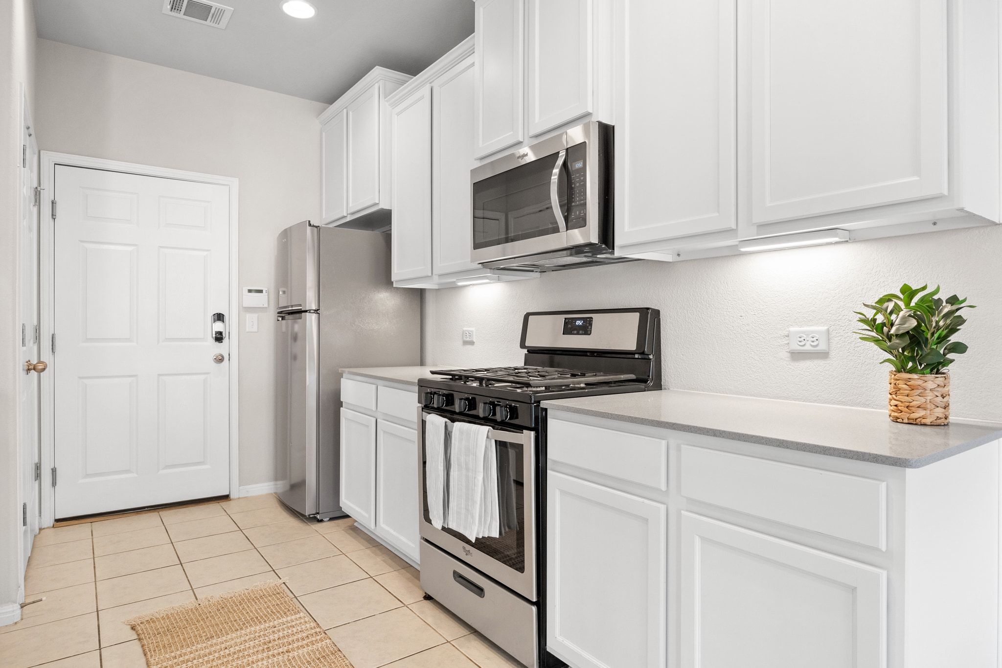1612 Catalan Road, Unit 201 Austin, TX 78748 - Photo 11 of 35 a kitchen with stainless steel appliances granite countertop white cabinets a refrigerator a stove a microwave and a sink