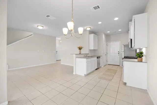 a large white kitchen with a lot of counter space and a sink