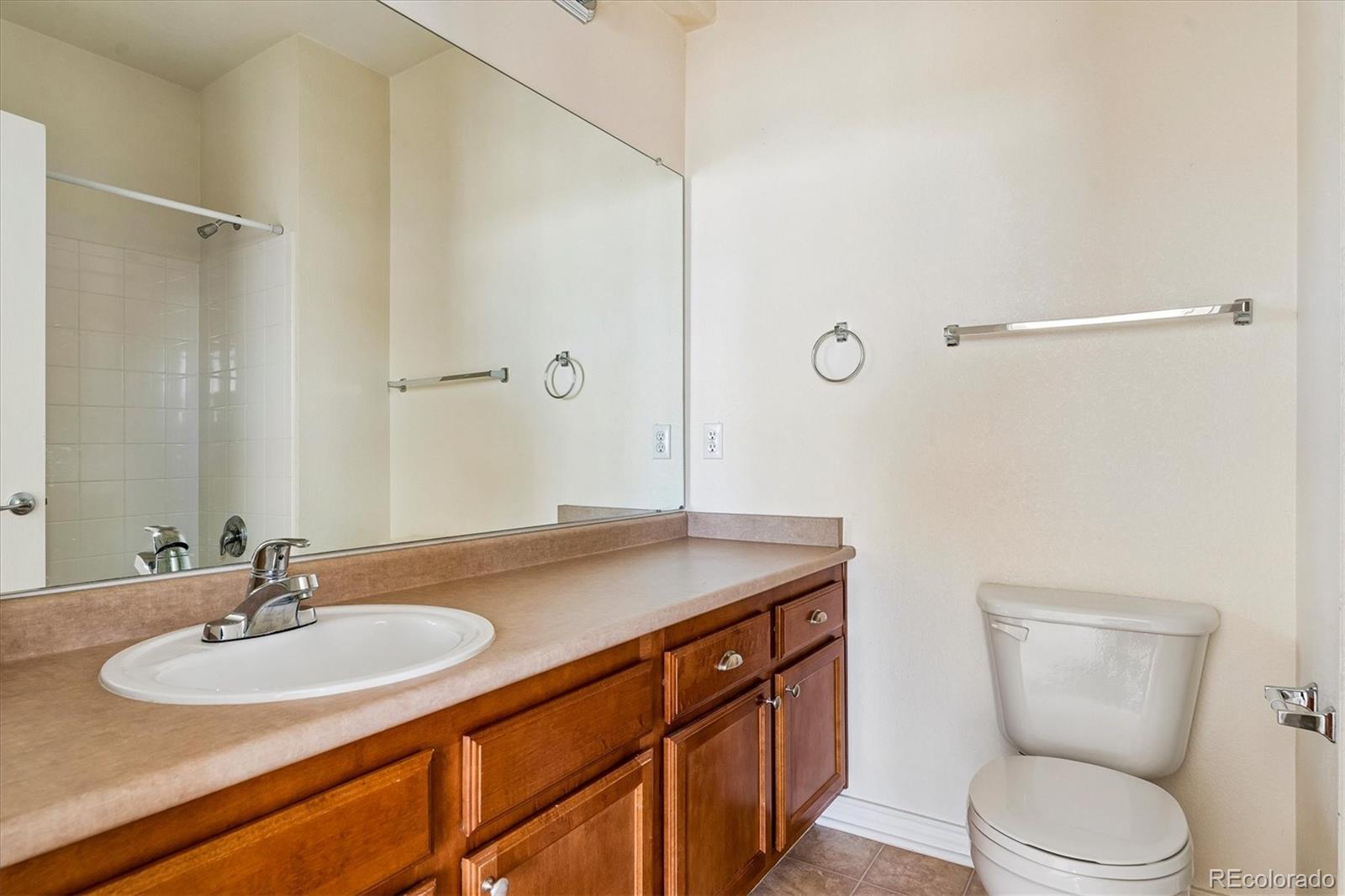 18657 Stroh Road, Unit 4207 Parker, CO 80134 - Photo 21 of 39 a bathroom with a granite countertop sink toilet a mirror and shower