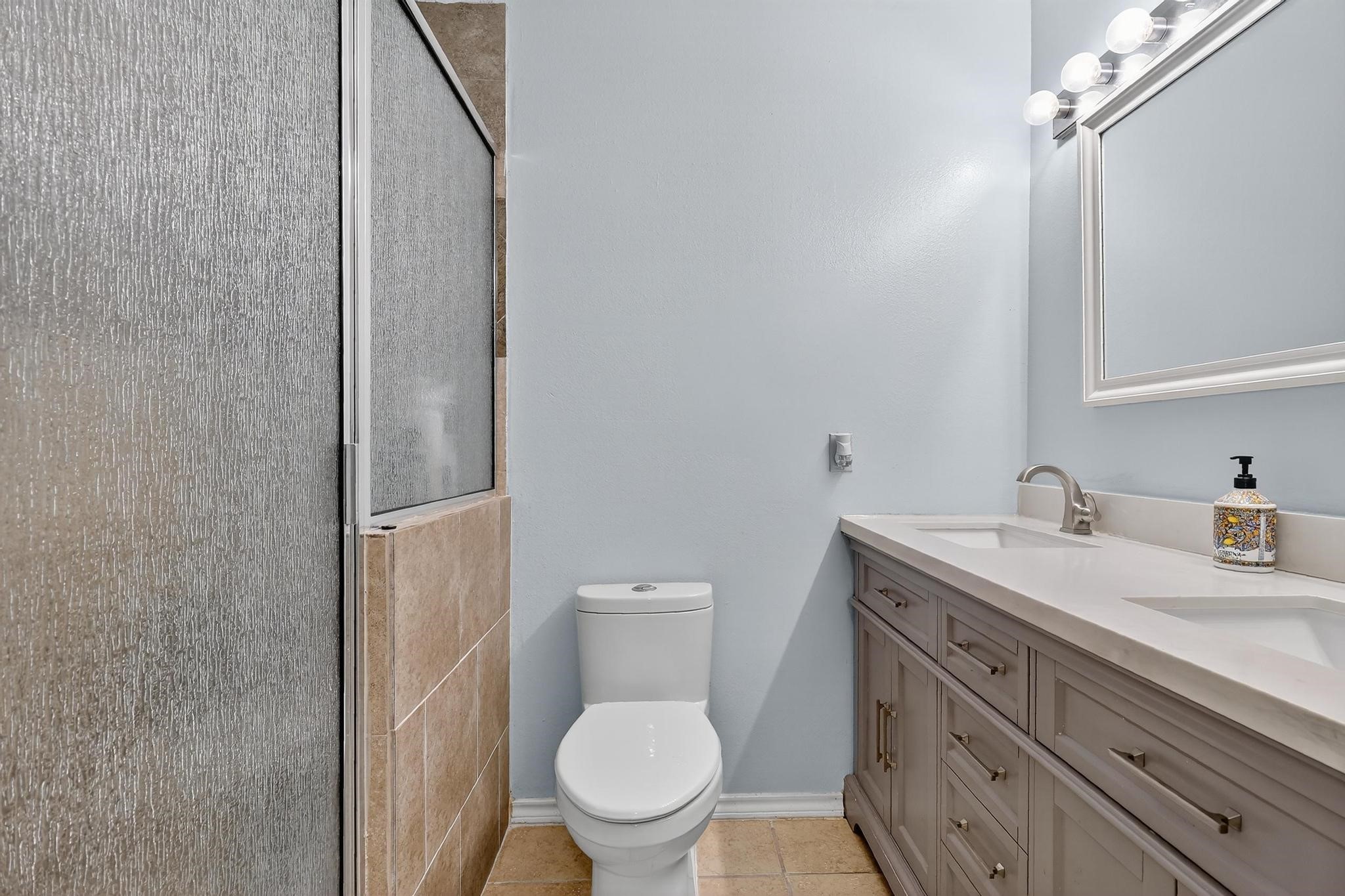 14418 Louetta Road Cypress, TX 77429 - Photo 27 of 39 a bathroom with a granite countertop toilet sink and mirror