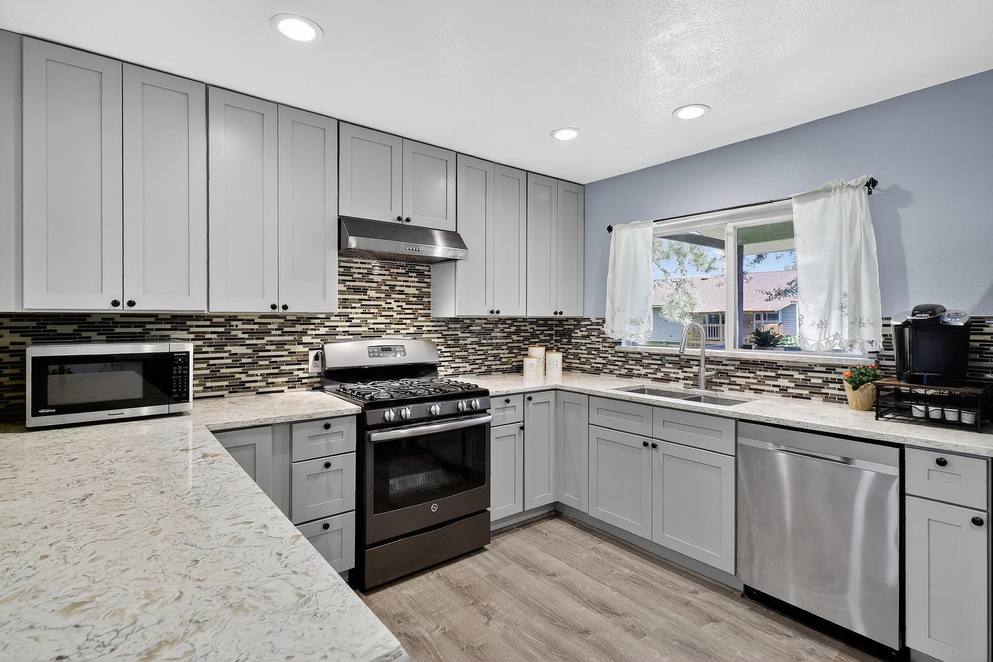14418 Louetta Road Cypress, TX 77429 - Photo 7 of 39 a kitchen with stainless steel appliances granite countertop a stove a sink and a microwave