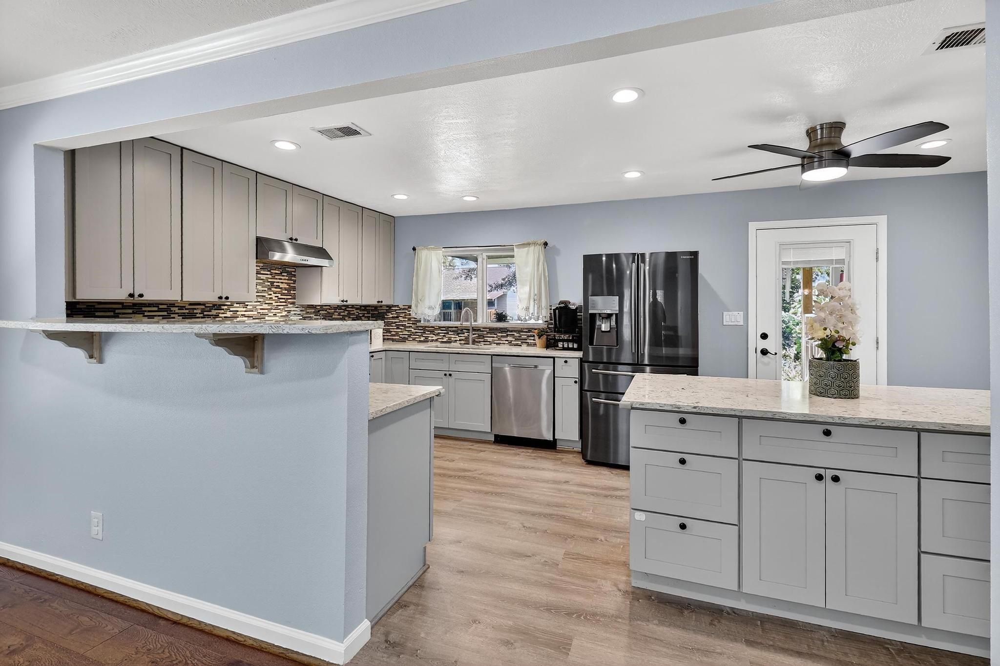 14418 Louetta Road Cypress, TX 77429 - Photo 9 of 39 a kitchen with kitchen island granite countertop a sink cabinets and stainless steel appliances