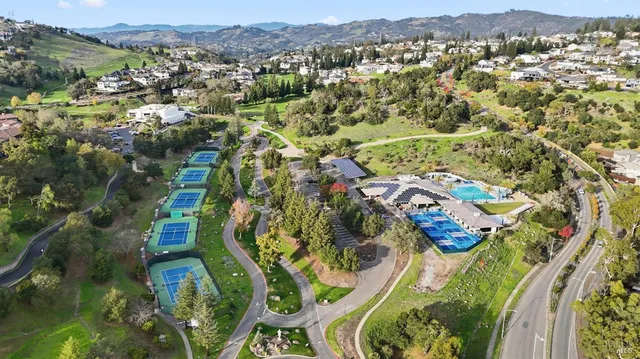 an aerial view of residential houses with outdoor space and trees