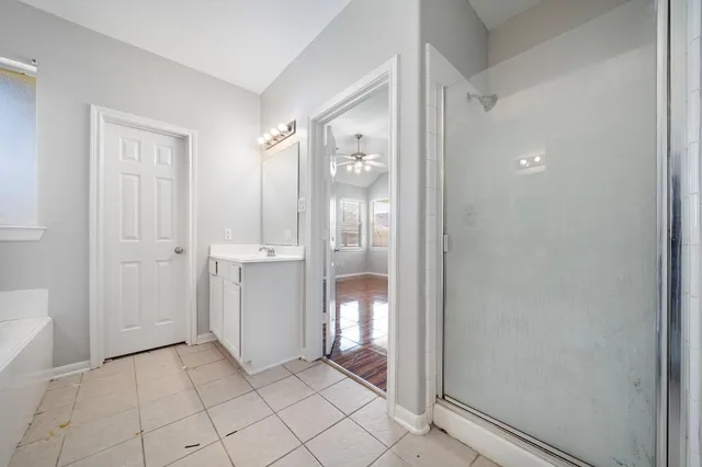 a bedroom with a bed and a chandelier fan