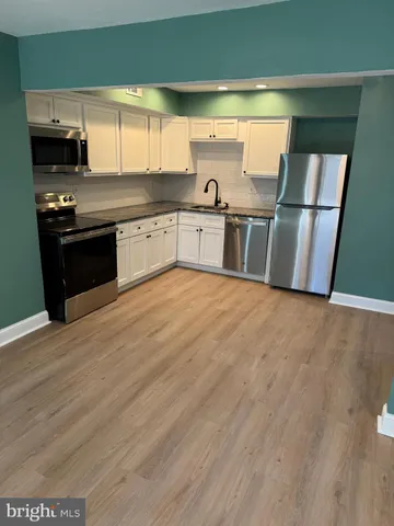 a view of hallway with stairs and wooden floor