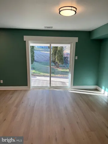 a view of a room with wooden floor and a window