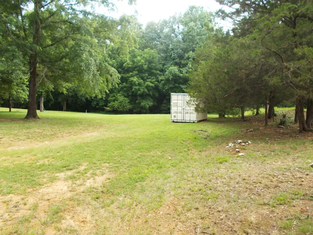 a view of a field with some trees in the background