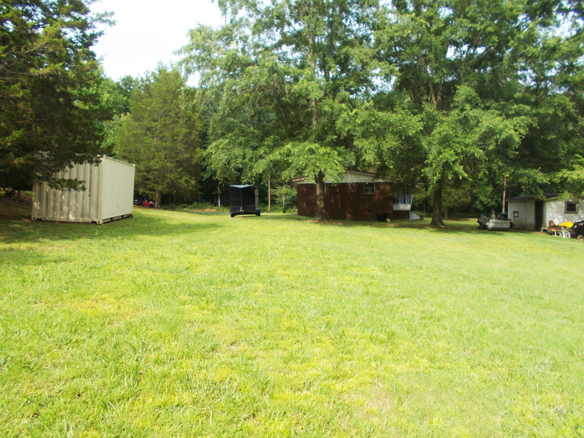 979 Highlander Road Camden, TN 38320 - Photo 21 of 23 a view of a swimming pool with a yard and large trees