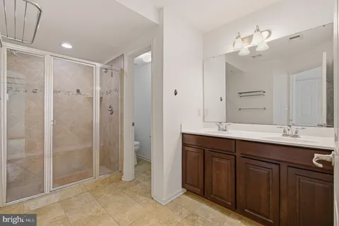 a bathroom with a double vanity sink mirror and shower