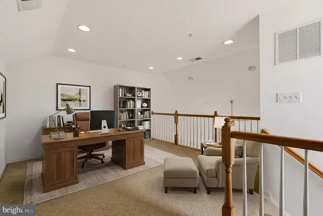 a view of a workspace with furniture and a window