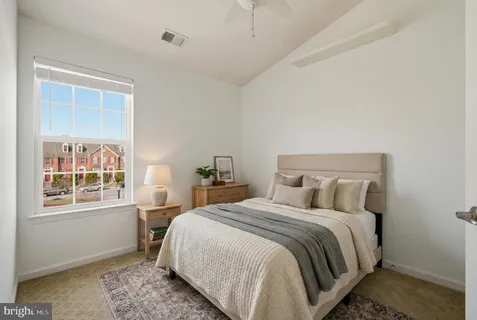 a bedroom with a bed next to a window