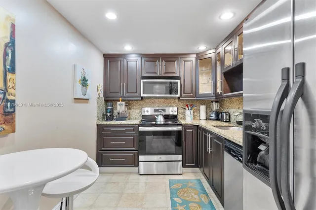 a kitchen with stainless steel appliances granite countertop a sink and cabinets