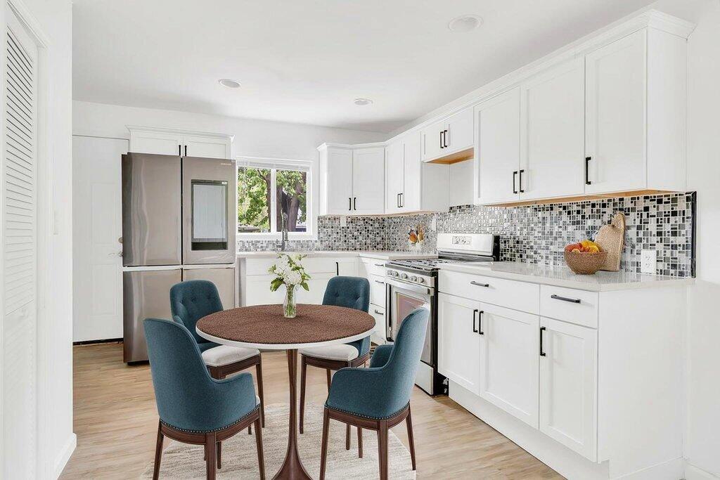 5247 West 3rd Avenue Gary, IN 46406 - Photo 6 of 16 a kitchen with stainless steel appliances a dining table and chairs