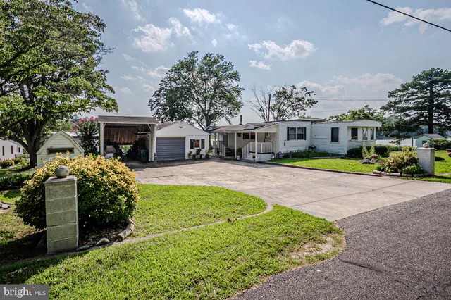 a front view of a house with a garden and trees