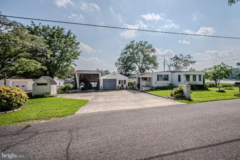 a front view of a house with a yard and potted plants