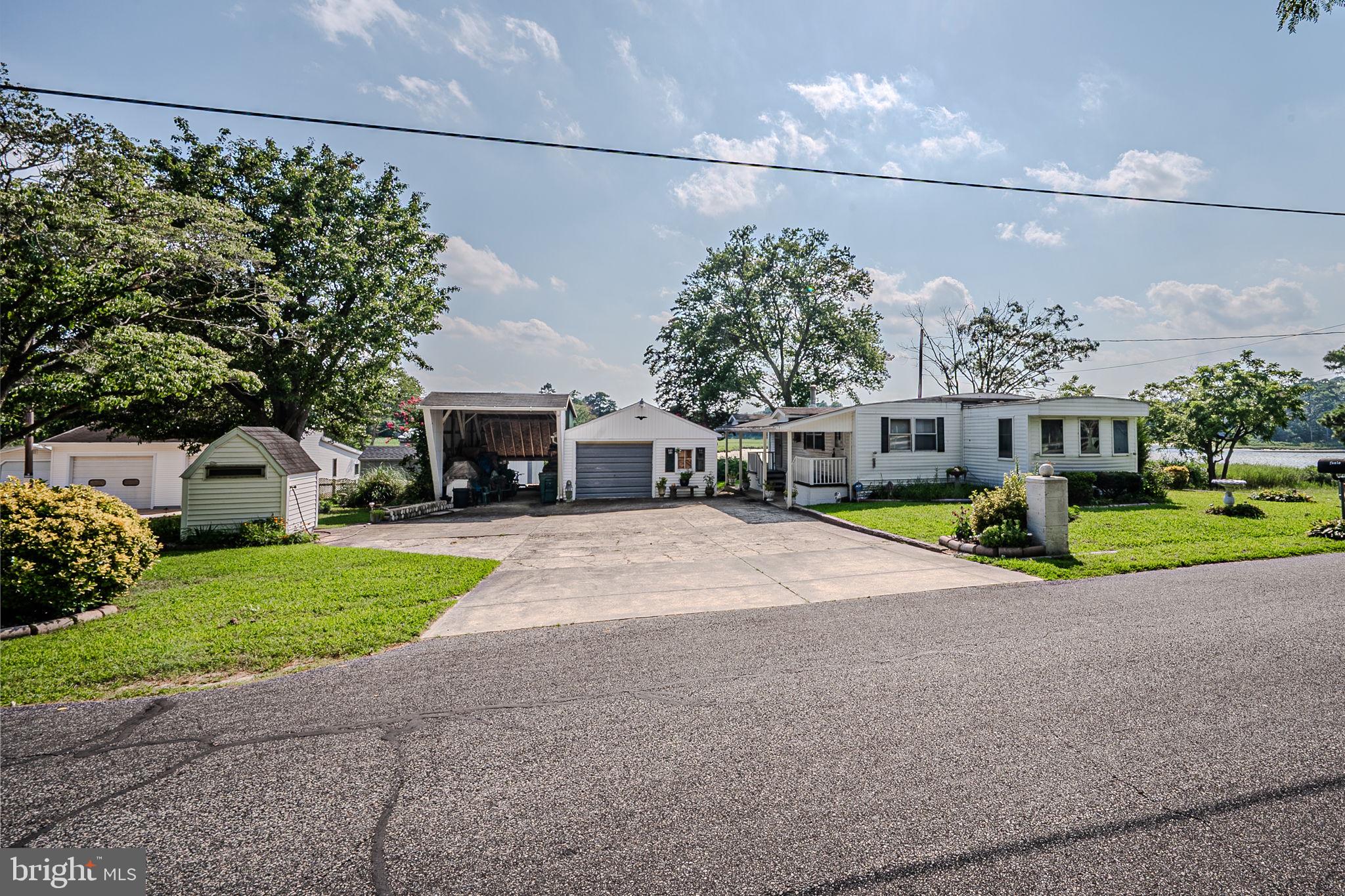 28050 Possum Point Road Millsboro, DE 19966 - Photo 17 of 47 a view of a house with a patio and a yard