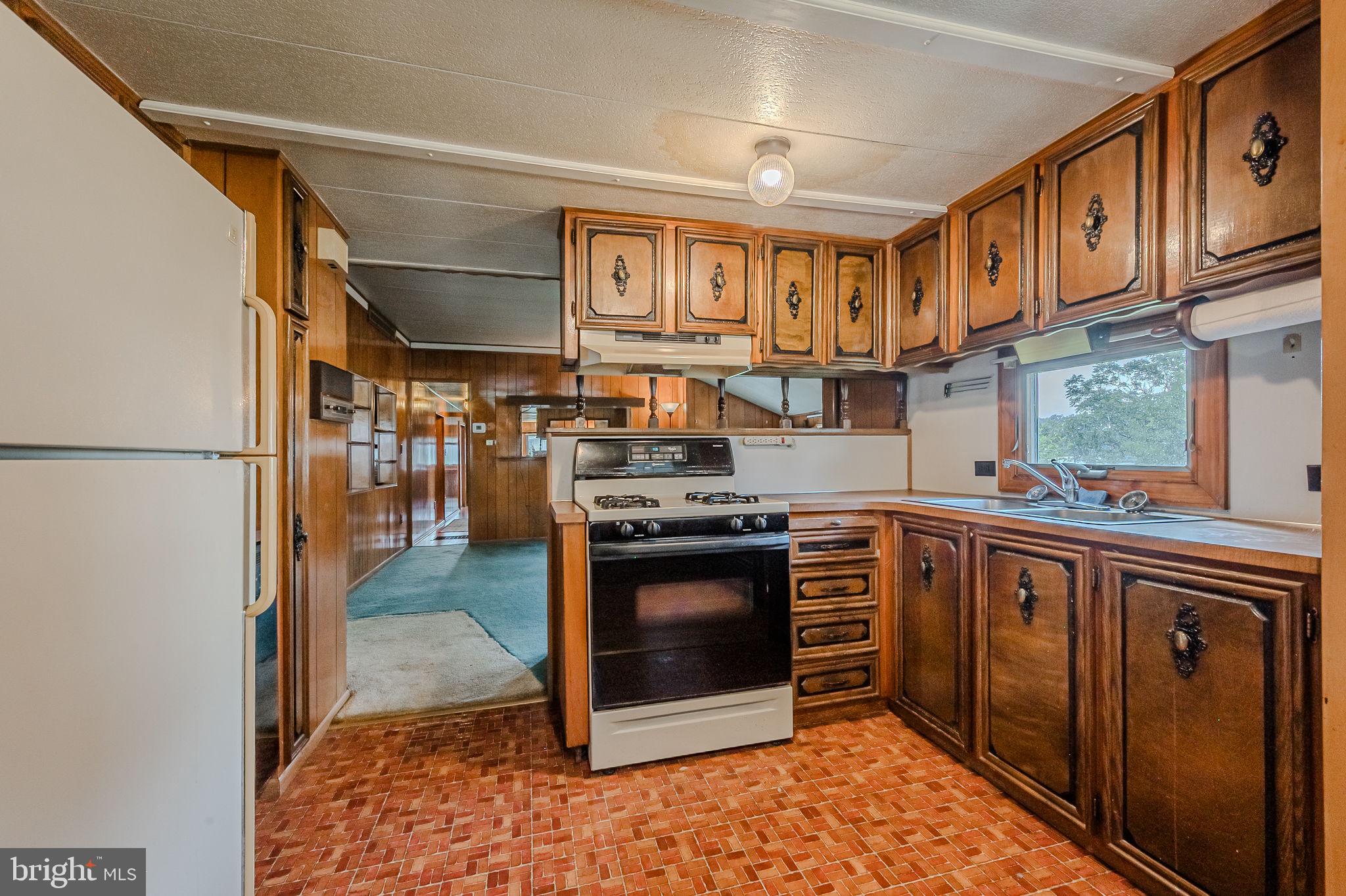 28050 Possum Point Road Millsboro, DE 19966 - Photo 30 of 47 a kitchen with stainless steel appliances granite countertop a stove a sink and a refrigerator