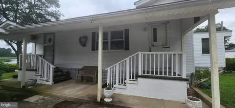 a view of a house with backyard and porch