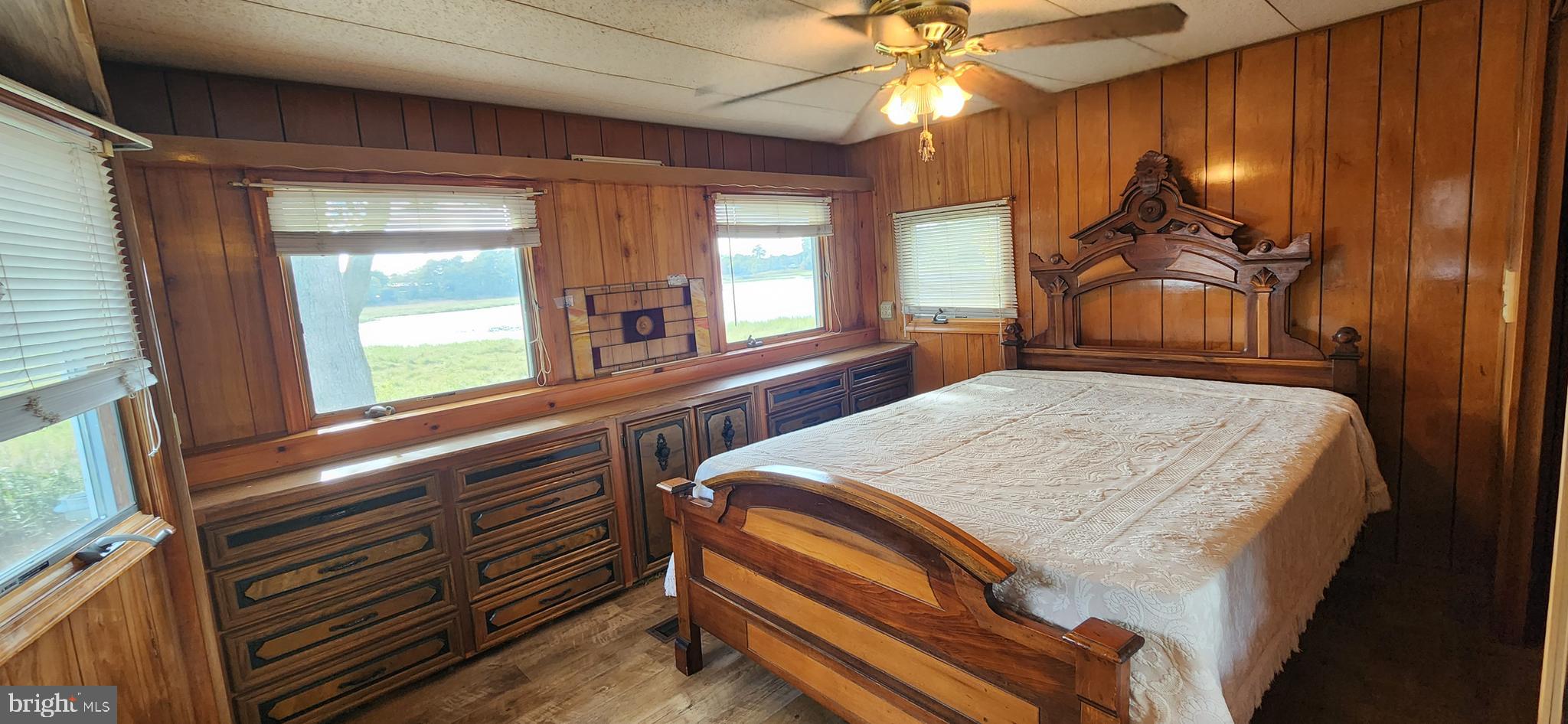 28050 Possum Point Road Millsboro, DE 19966 - Photo 34 of 47 a bedroom with a bed and a chandelier