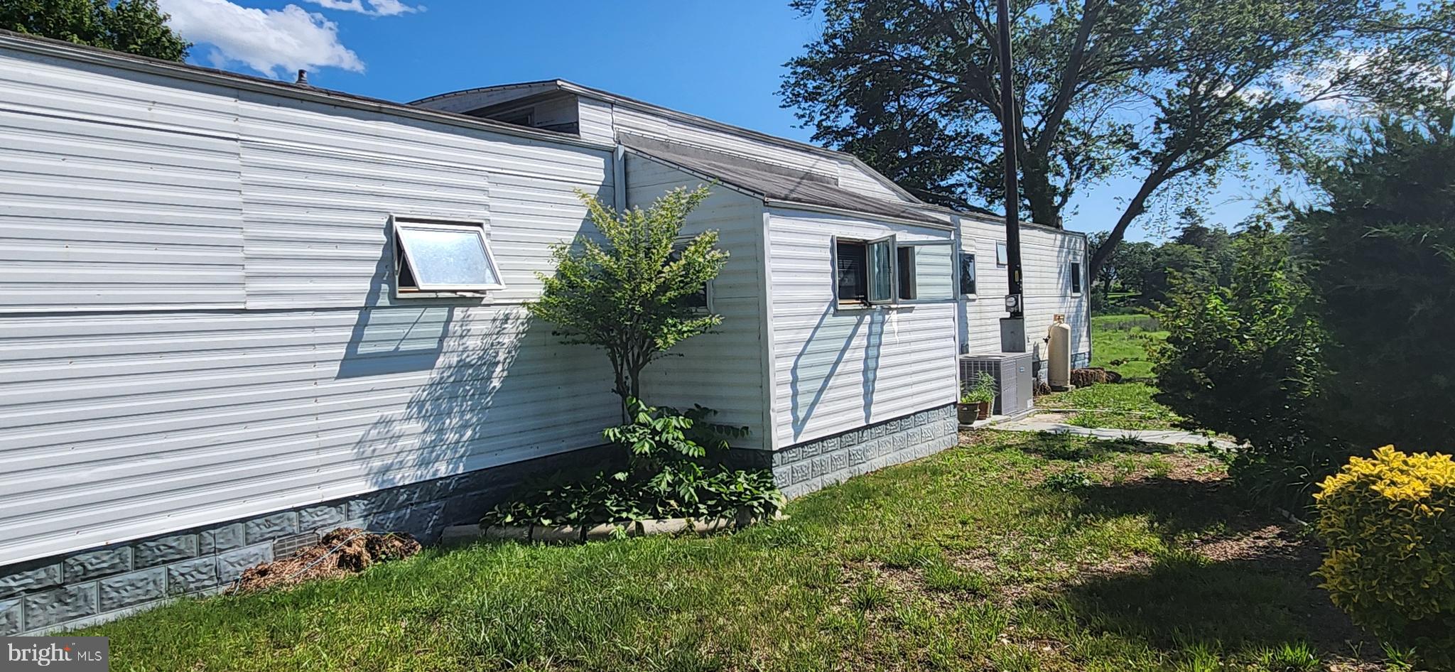 28050 Possum Point Road Millsboro, DE 19966 - Photo 10 of 47 a yellow house with flower garden in front of it