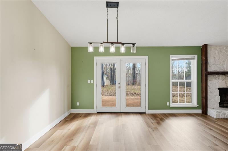 4450 Dorsett Shoals Road Douglasville, GA 30135 - Photo 14 of 36 an empty room with wooden floor chandelier and windows