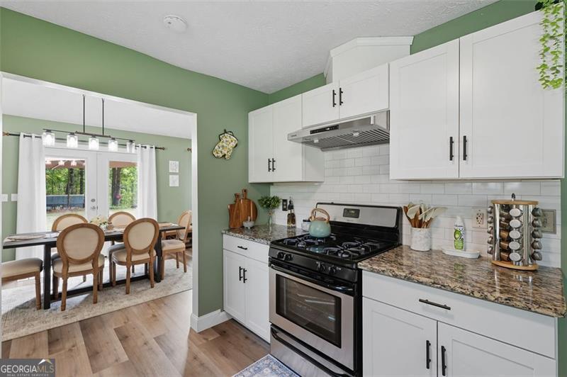 4450 Dorsett Shoals Road Douglasville, GA 30135 - Photo 17 of 36 a kitchen with stainless steel appliances granite countertop a stove and a white cabinets