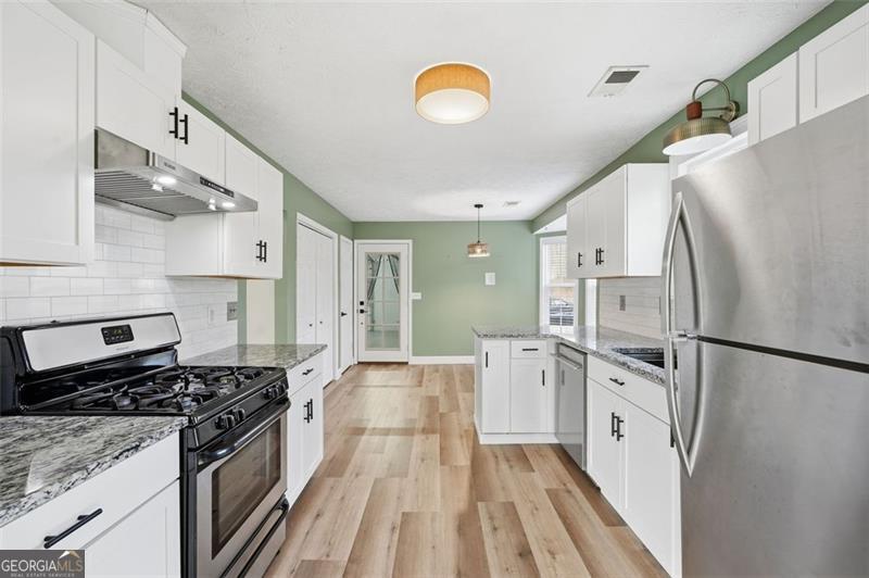 4450 Dorsett Shoals Road Douglasville, GA 30135 - Photo 18 of 36 a kitchen with white cabinets and stainless steel appliances