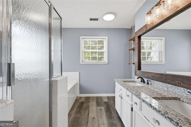 4450 Dorsett Shoals Road Douglasville, GA 30135 - Photo 24 of 36 a spacious bathroom with a granite countertop sink a mirror and a shower