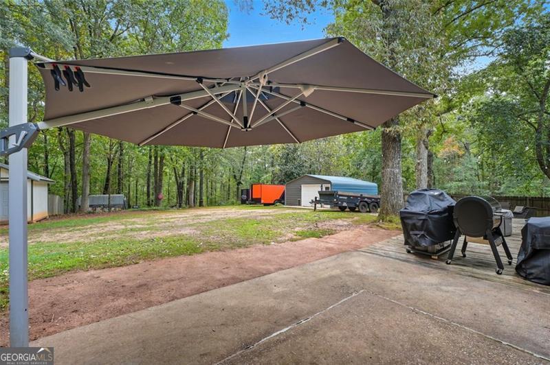 4450 Dorsett Shoals Road Douglasville, GA 30135 - Photo 33 of 36 a backyard of a house with table and chairs under an umbrella