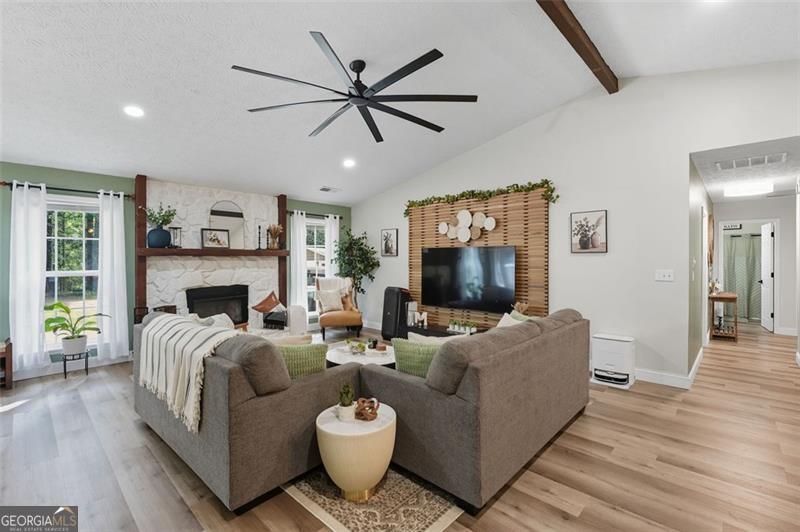 4450 Dorsett Shoals Road Douglasville, GA 30135 - Photo 6 of 36 a living room with furniture a flat screen tv and a fireplace