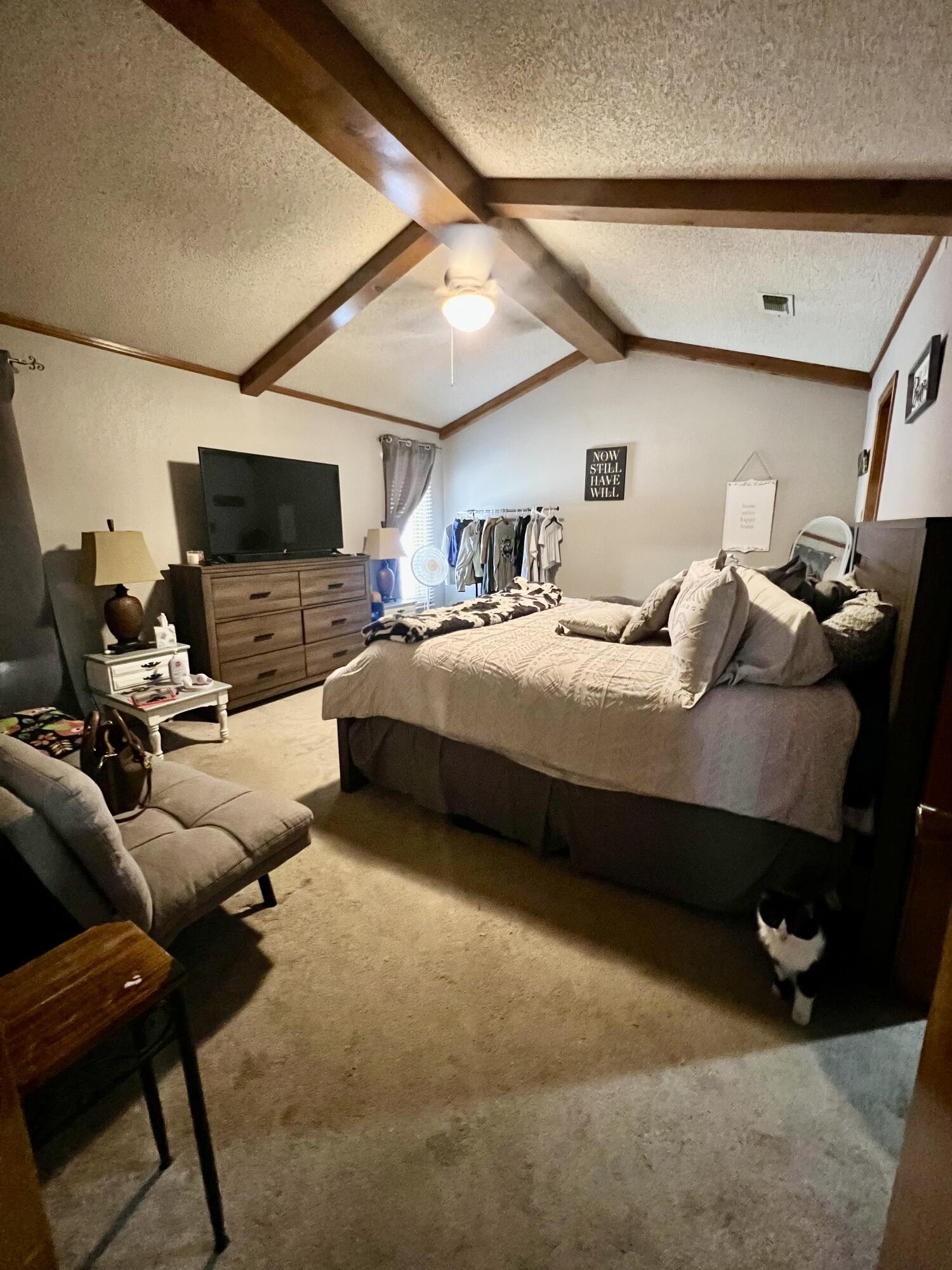 5725 63rd Street Lubbock, TX 79424 - Photo 7 of 14 a bedroom with furniture and a flat screen tv