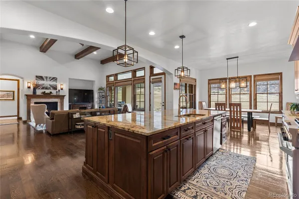 a open kitchen with stainless steel appliances granite countertop a stove and a view of living room