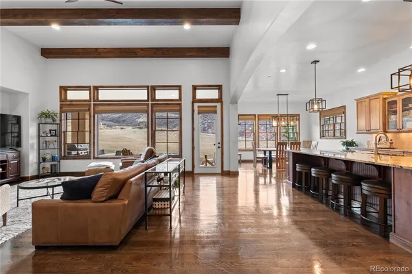 a living room with fireplace furniture and a large window