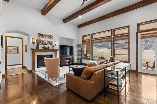a living room with fireplace furniture and a large window