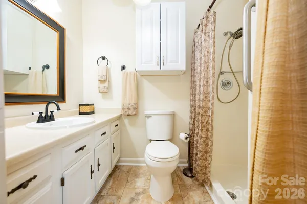 a bathroom with a granite countertop sink toilet and shower