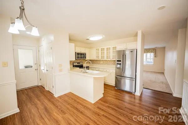 a kitchen with stainless steel appliances a refrigerator and wooden floor