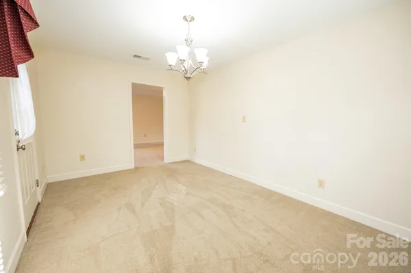 a view of an empty room with a chandelier
