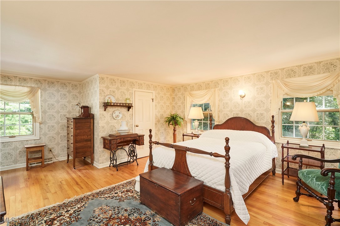 11715 Dunham Road Northfield, OH 44067 - Photo 14 of 19 Bedroom featuring wallpapered walls, wood finished floors, and multiple windows