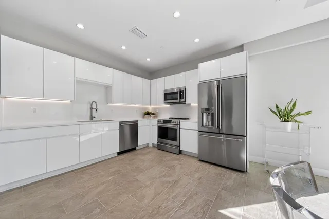 a kitchen with white cabinets and stainless steel appliances